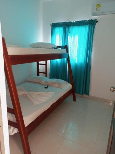 2 stapelbedden in een kamer met een blauw gordijn bij Apartamentos Mi Reserva OK - Miraluna in Coveñas