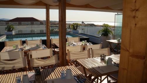 a restaurant with tables and chairs and a swimming pool at Lagos Center Studios in Lagos