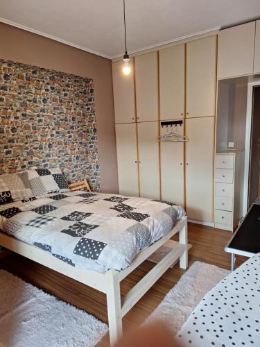 een slaapkamer met een bed en een bakstenen muur bij Άρτεμις in Levádeia