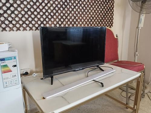 TV de pantalla plana grande en la parte superior de una mesa en Sebstian Rooms en Madaba