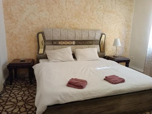 1 dormitorio con 1 cama grande y 2 toallas. en Sebstian Rooms en Madaba