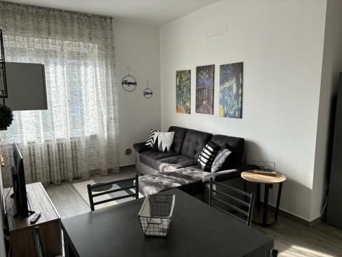 uma sala de estar com um sofá e uma mesa em Sweet house Malpensa em Somma Lombardo