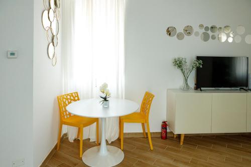 una sala da pranzo con tavolo, 2 sedie e TV di Brixia Charm Studio a Brescia