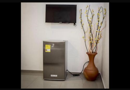 um pequeno frigorífico ao lado de um vaso e uma televisão em HOTEL NUEVO ARIZONA em Cartagena das Índias
