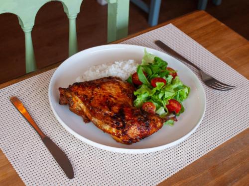 a plate of chicken and rice and salad on a table at Hotel Ajax in Punta del Este
