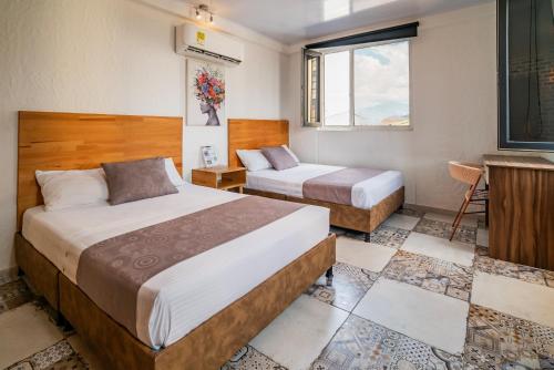 a hotel room with two beds and a window at Casa del Sol in Villavicencio