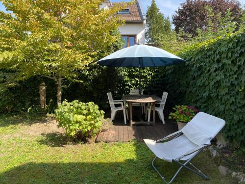 un patio avec une table, des chaises et un parasol dans l'établissement Chambre en duplex, entrée autonome, SDB privative, à Taverny