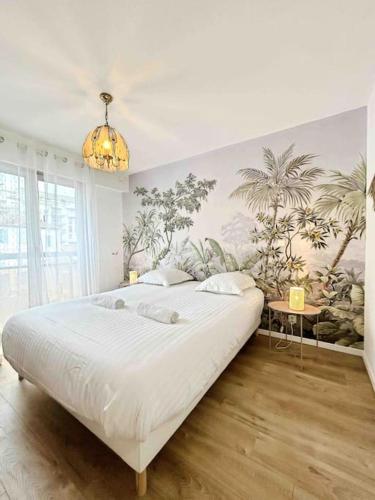 une chambre avec un grand lit et un lustre dans l'établissement La Petite Louisiane : Apt 4 Prs, 300 m plages, à Antibes