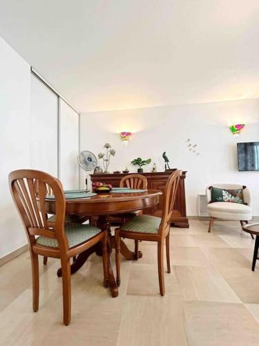 une salle à manger avec une table et des chaises en bois dans l'établissement La Petite Louisiane : Apt 4 Prs, 300 m plages, à Antibes