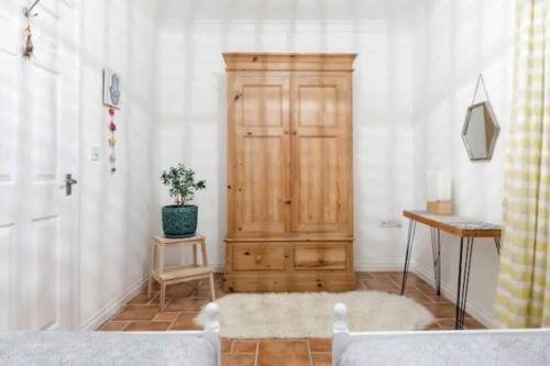 a room with a wooden cabinet and a potted plant at Charlestown Cottage Harbour & Beach short walk! in Charlestown