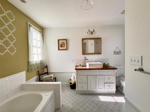 a bathroom with a bath tub and a sink at The Sunnyside Sisters Bed and Breakfast in Clarksville