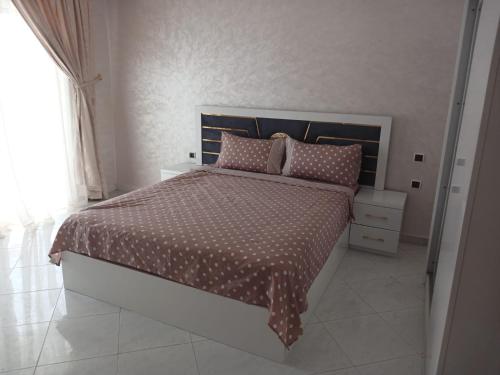 1 dormitorio con 1 cama con edredón marrón y blanco en Ketama ketama ketama en Tlata Ketama