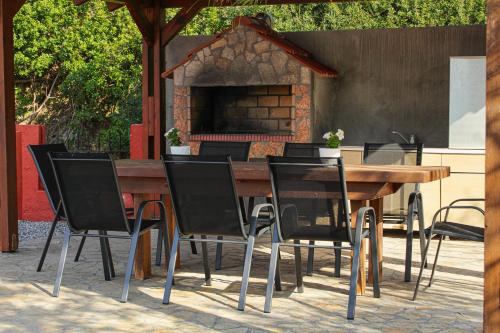 a wooden table and chairs in front of a fireplace at Angels beach house in Rhodes Town