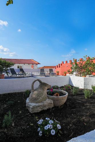 a statue of a jug with flowers in a garden at Angels beach house in Rhodes Town
