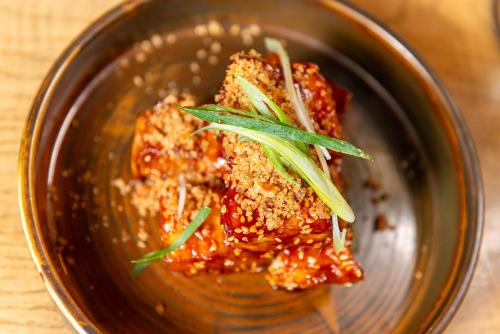 a bowl of food with sauce and greens on top at Bosuns Chair in Lymington