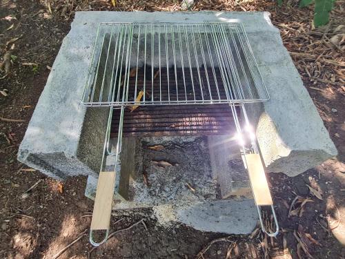 a grill with two sticks in front of it at La kaz nature bien-être in Petit-Bourg