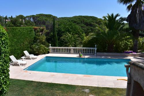 - une piscine dans une cour avec 2 chaises dans l'établissement Appartement Rez de Villa - 4 personnes - Fréjus - Vue piscine, à Fréjus