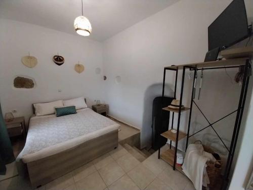 ein kleines Schlafzimmer mit einem Bett und einem TV in der Unterkunft Studio Rafaela in Matala