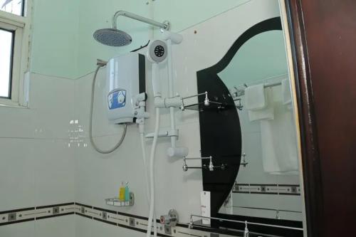 a shower in a bathroom with a mirror at Jade Spa and Hotel in Kasese