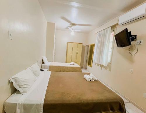 Habitación de hotel con 2 camas y TV de pantalla plana. en Hotel Ibiá, en Montenegro