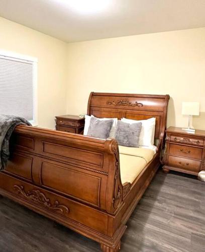 a bedroom with a large wooden bed with pillows at modern rustic apartment in St. John's