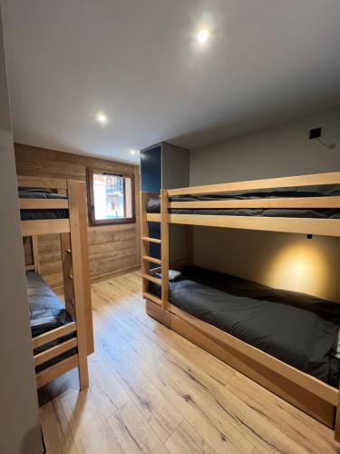 a room with three bunk beds in a house at Galibier & Spirit in Valloire