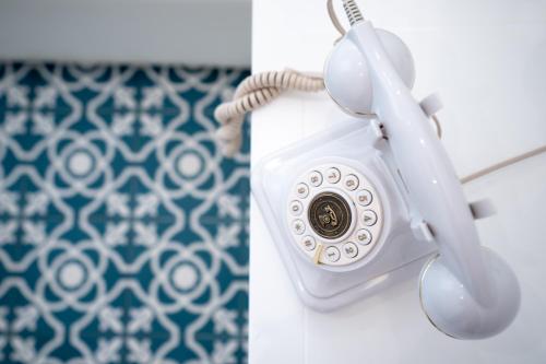 a white phone is hanging on a wall at BADIA NUOVA Apart Hotel in Trapani