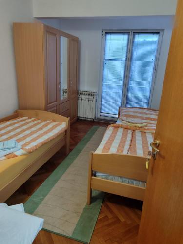 a room with two beds and a door open at Villa Artemida in Kulen Vakuf