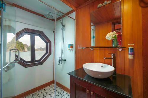 a bathroom with a sink and a glass shower at Majestic Legend Cruise in Ha Long