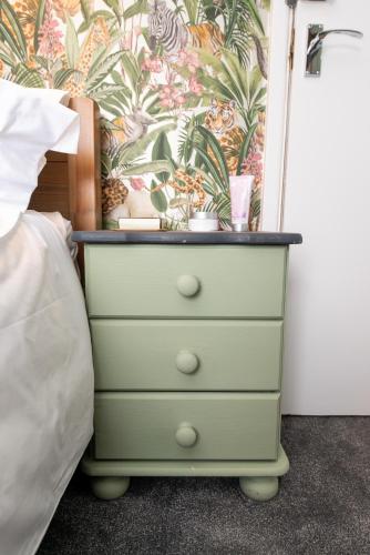 a green dresser next to a bed in a bedroom at Bosuns Chair in Lymington