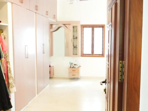 um quarto com um corredor com armários brancos e uma janela em FRENCH COURTYARD HOUSE em Bangalore