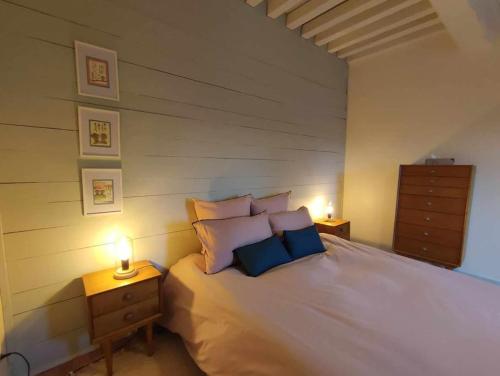 een slaapkamer met een groot bed met 2 nachtkastjes bij La maison du Boulanger in Pontaubert