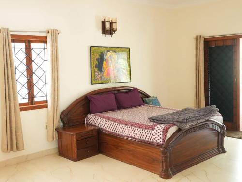 um quarto com uma cama de madeira num quarto em FRENCH COURTYARD HOUSE em Bangalore