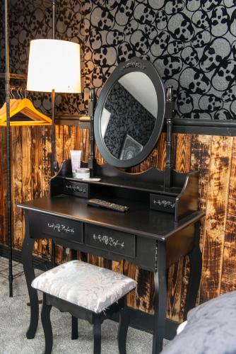 a black dressing table with a mirror and a stool at Bosuns Chair in Lymington