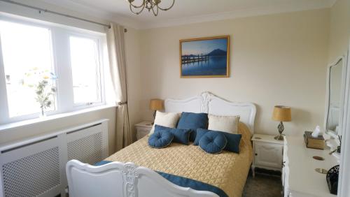 a bedroom with a white bed with blue pillows at Parkin House Guest House in Todmorden