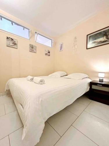 une chambre avec un grand lit avec des draps blancs dans l'établissement Le Roi Soleil : Apt 2 Prs vue mer, 300 m plages, à Antibes