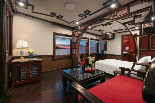 a train room with a bed and a table at Majestic Legend Cruise in Ha Long