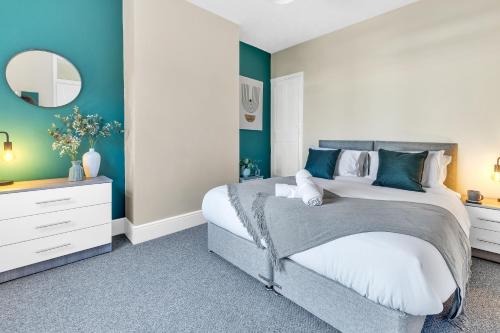 a bedroom with a large bed and a mirror at Inspira Stays - Monthly DISCOUNTS - Stylish Modern 2 Bedroom House - Free Parking - Wi-Fi in Leicester