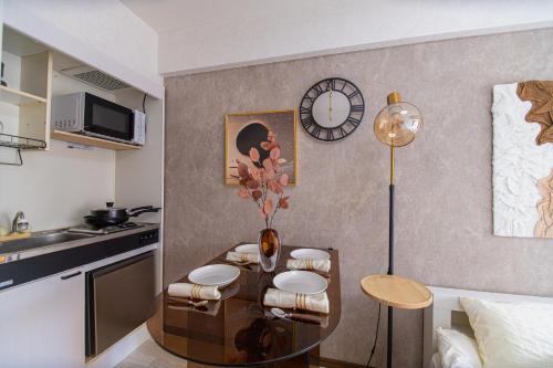 a kitchen with a table with chairs and a clock at G59新宿最中心 東新宿站5分-Shinjuku center 5 mins to Station, Max 4 直达新宿 涉谷 表参道 池袋 上野 代代木 银座 原宿 in Tokyo