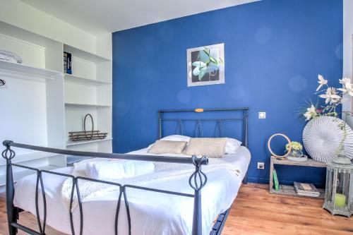 une chambre avec un mur bleu et un lit dans l'établissement Chez Mimi, à Saint-Pierre-de-Chignac