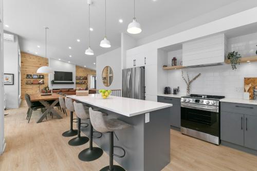 a kitchen with a large island with bar stools at Le Singapour - Cottage Resort - Brownsburg-Chatham in Brownsburg