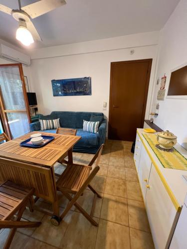 une cuisine et un salon avec une table et un canapé dans l'établissement Casetta Anna, à Santa Marinella