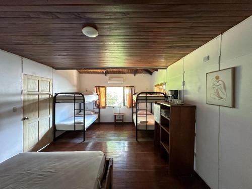 a room with two bunk beds and a room with a kitchen at El Clan Hostel in Puerto Viejo