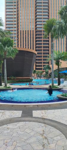 a large swimming pool with palm trees and buildings at Best Facilities Services Suites At Times Square kl in Kuala Lumpur