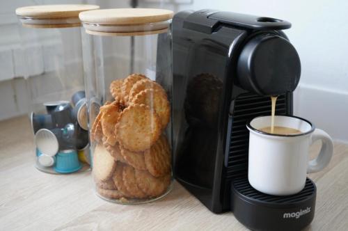 a coffee maker with a cup of coffee and some pastries at Apt Parisian Charm with Amazing View Near Metro in Asnières-sur-Seine