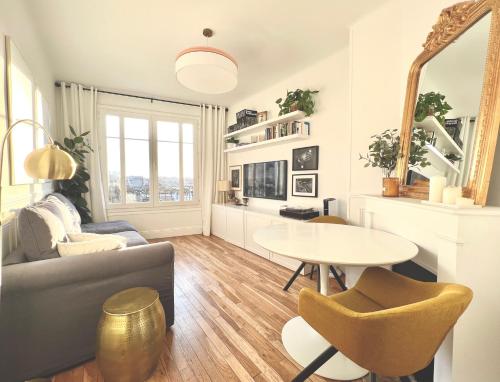 a living room with a couch and a table at Apt Parisian Charm with Amazing View Near Metro in Asnières-sur-Seine