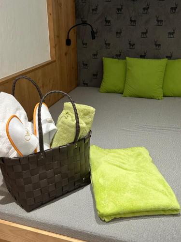 a basket of towels sitting on top of a bed at Hotel Hubertushof - Ihr Hotel mit Herz in Leutasch