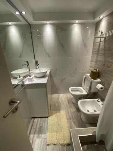 a bathroom with two sinks and two toilets at DEPARTAMENTO CENTRICO CON COCHERA - CORDOBA Argentina- in Cordoba