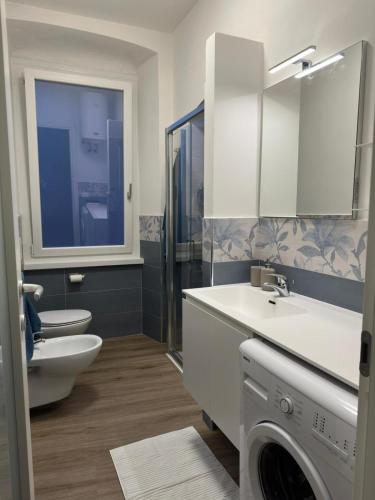 a bathroom with a toilet and a sink and a washing machine at Cuore di Lerici , amazing view in Lerici