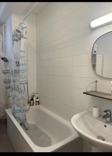 une salle de bain blanche avec une baignoire et un lavabo dans l'établissement Appartement Paris centre, à Paris